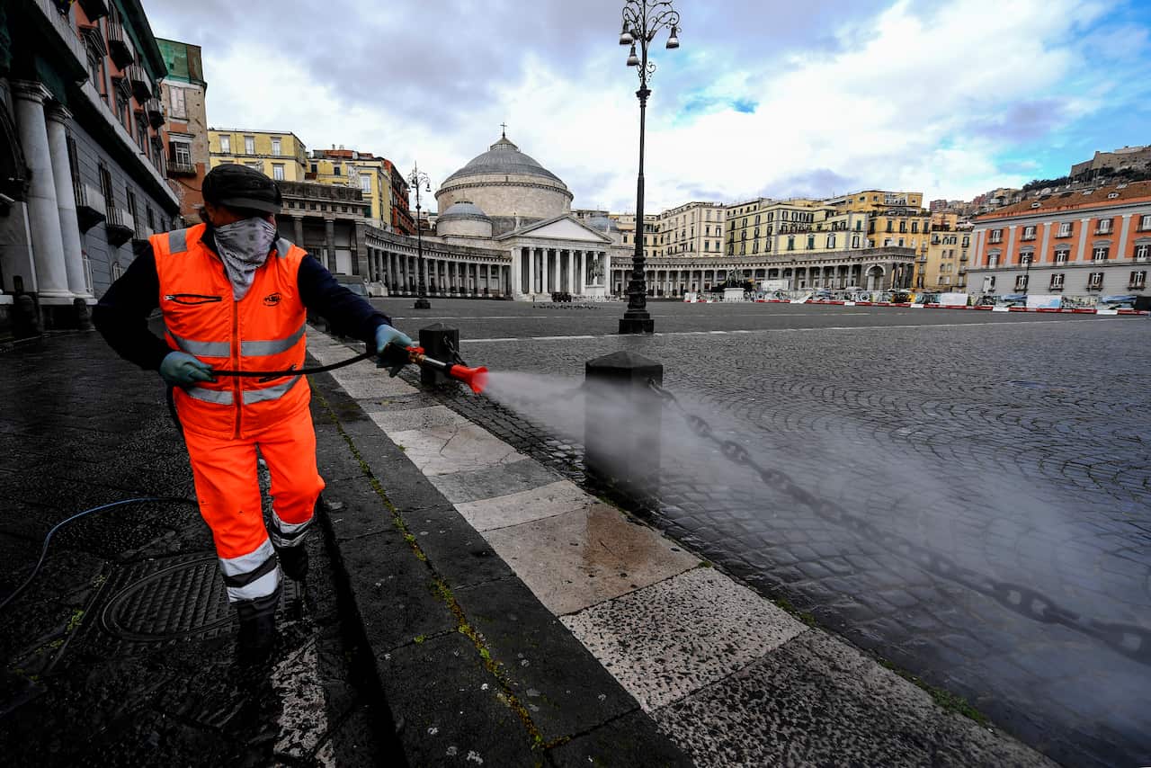 Sanitary workers disinfect the Plebiscito square, in Naples city