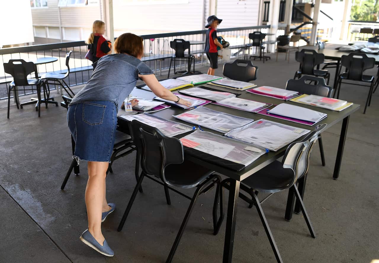 A teacher prepares a take-home activity packs at a primary school in Brisbane