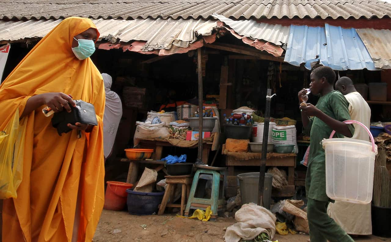 A Nigerian woman shops before lockdown at the Kado fish market in Abuja, Nigeria, 30 March 2020. 