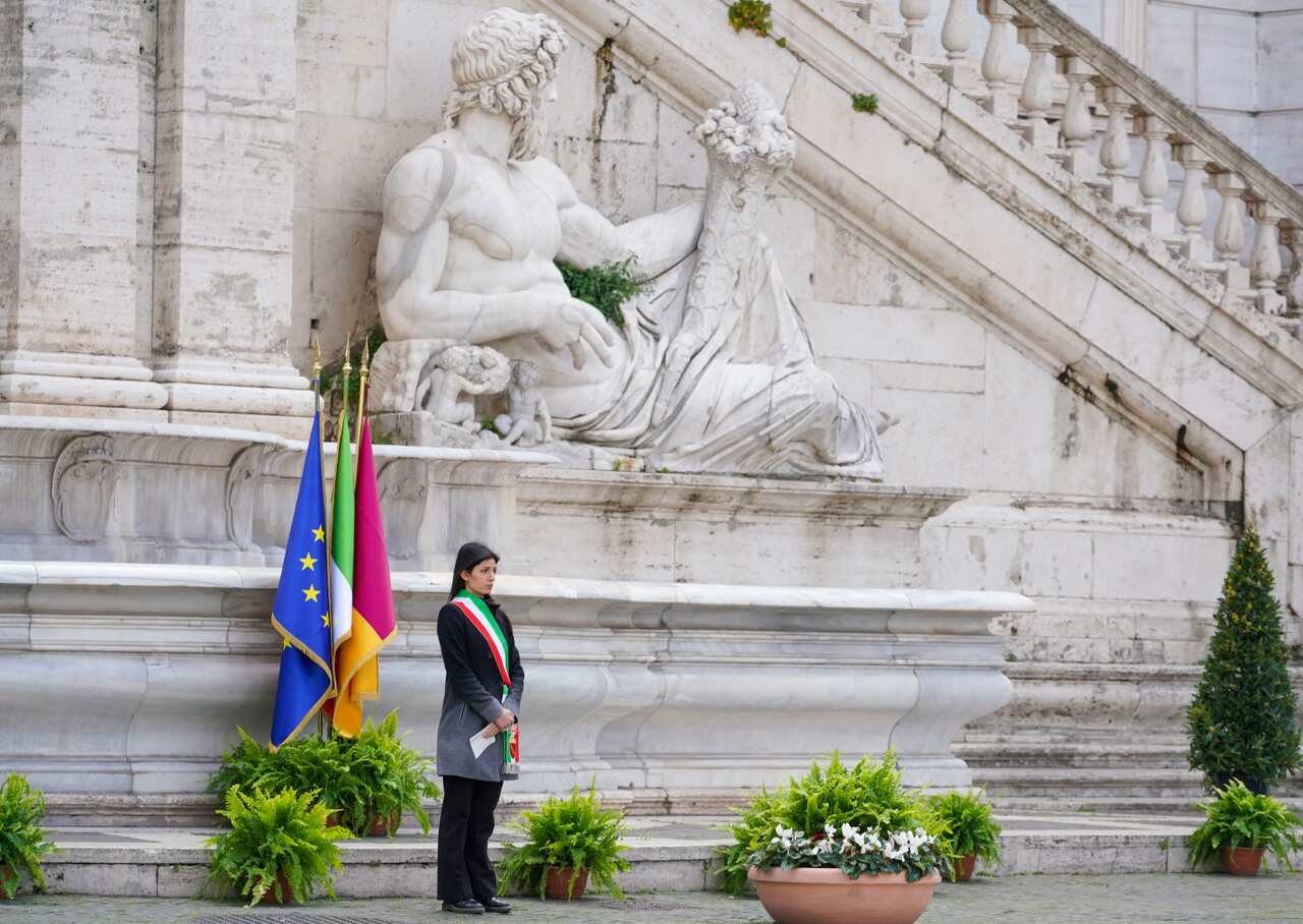 Rome's Mayor Virginia Raggi stands in front of flags at half-staff during the minute of silence.