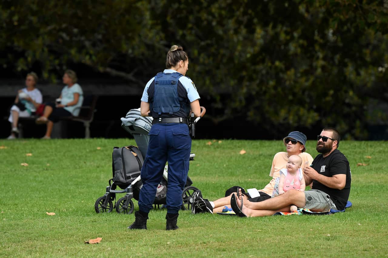 NSW Police officers ask a family to move on while on patrol at Rushcutters Bay park in Sydney.
