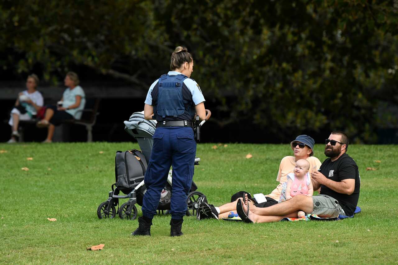 NSW Police officers ask a family to move on while on patrol at a Rushcutters Bay park in Sydney.
