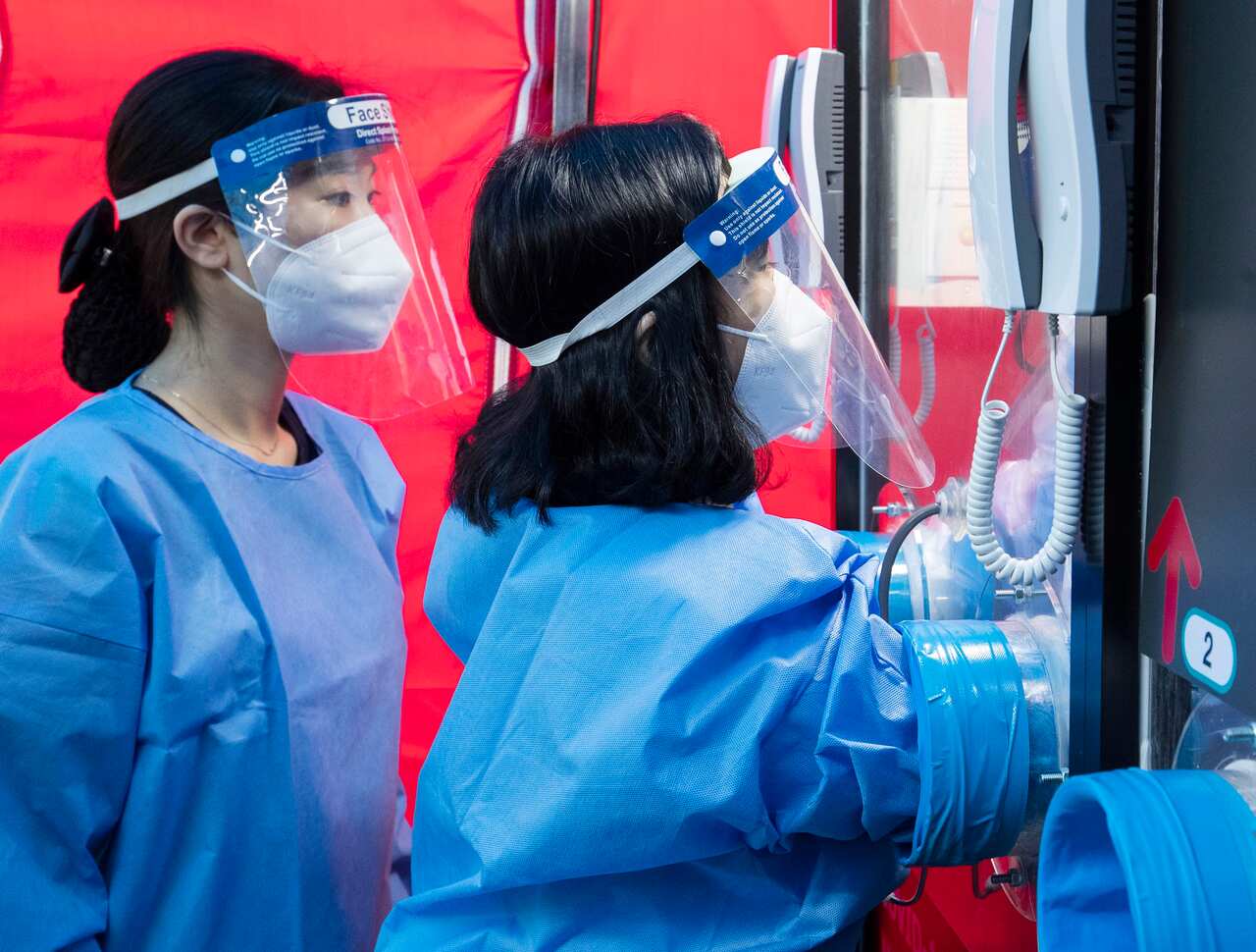 A medical team takes a swab from one of South Korea's phone booth-style testing sites.
