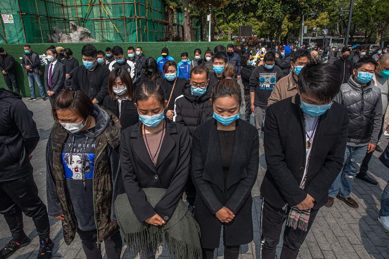 Crowds in Wuhan pause to pay their respects to the victims of COVID-19.