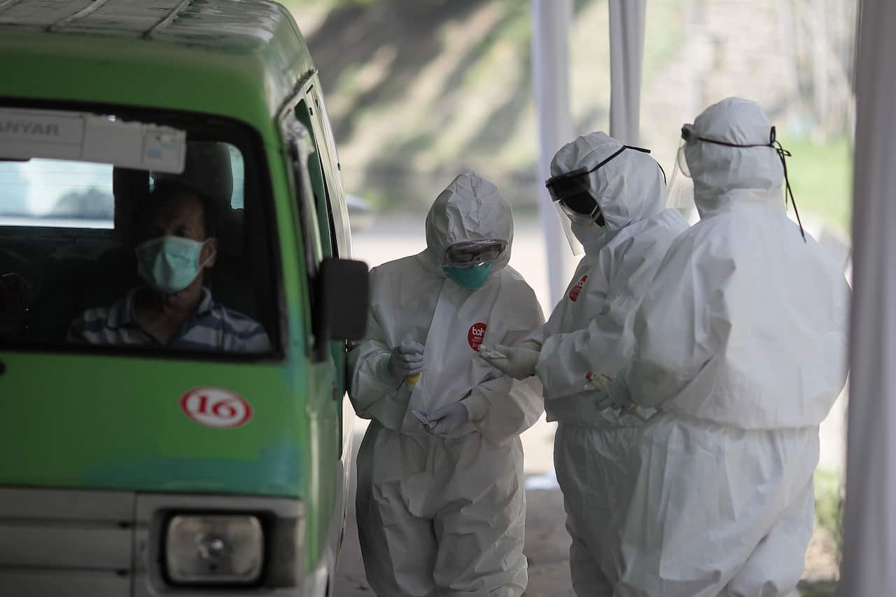 Health workers wearing protective suits check citizens during the COVID-19 rapid test in West Java, Indonesia.