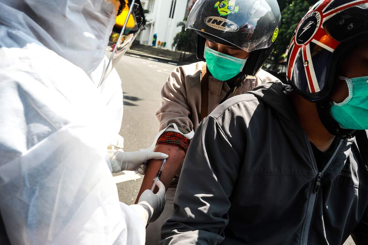 A motorcyclist gets a drive-through COVID-19 test in Bandung, West Java.