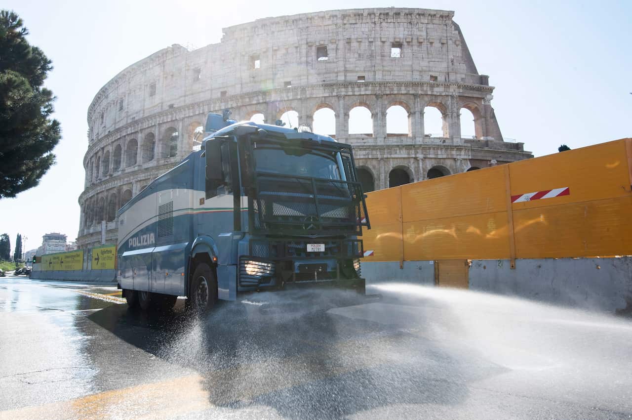 To fight the Coronavirus Italian police use vehicles equipped with water cannons to clean the streets Rome at the Colosseum, Rome, Italy.