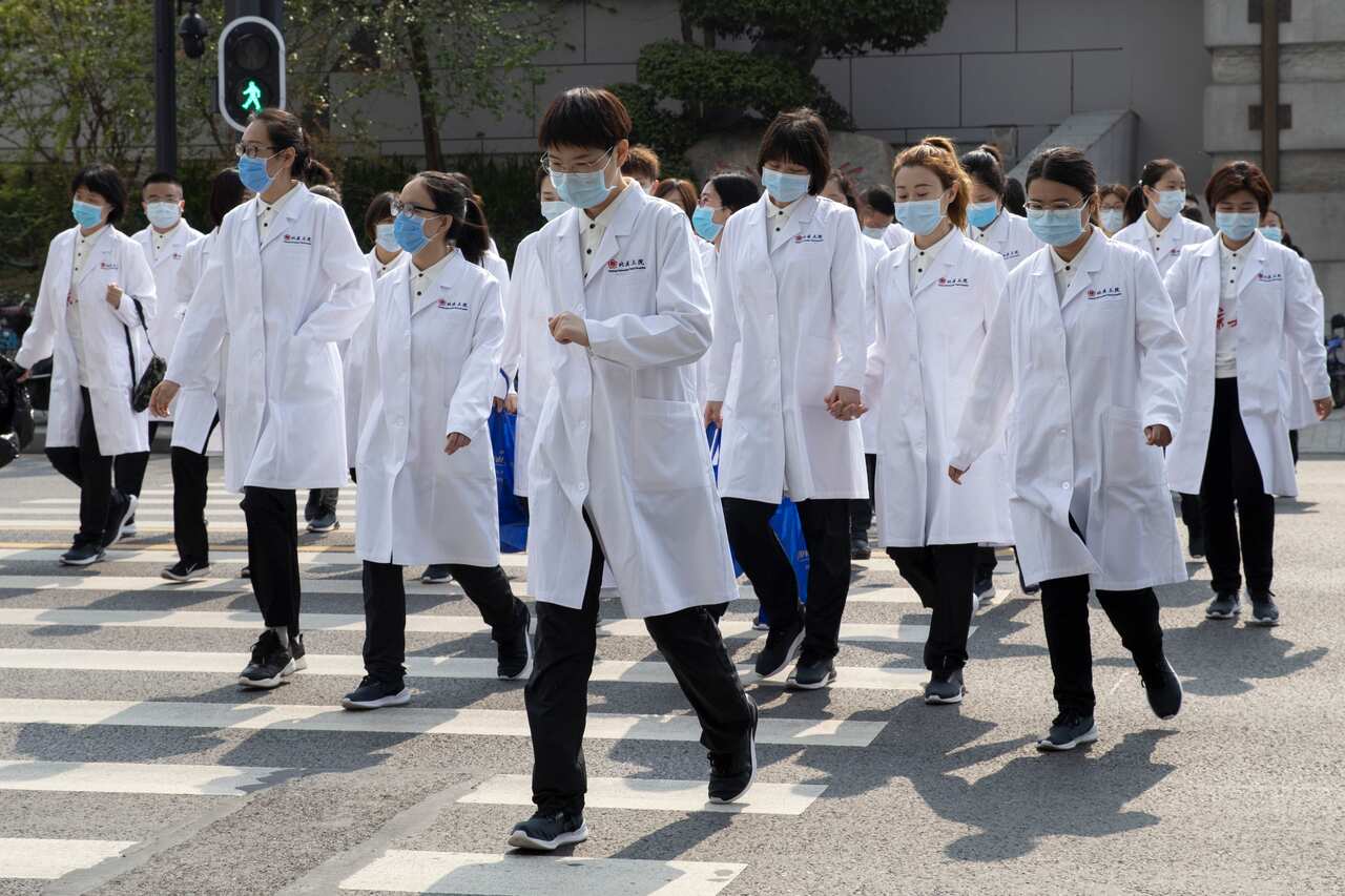 Medical workers walk near a park during a day off as the city of Wuhan slowly loosens up the lockdown in China's Hubei province on 5 April, 2020.