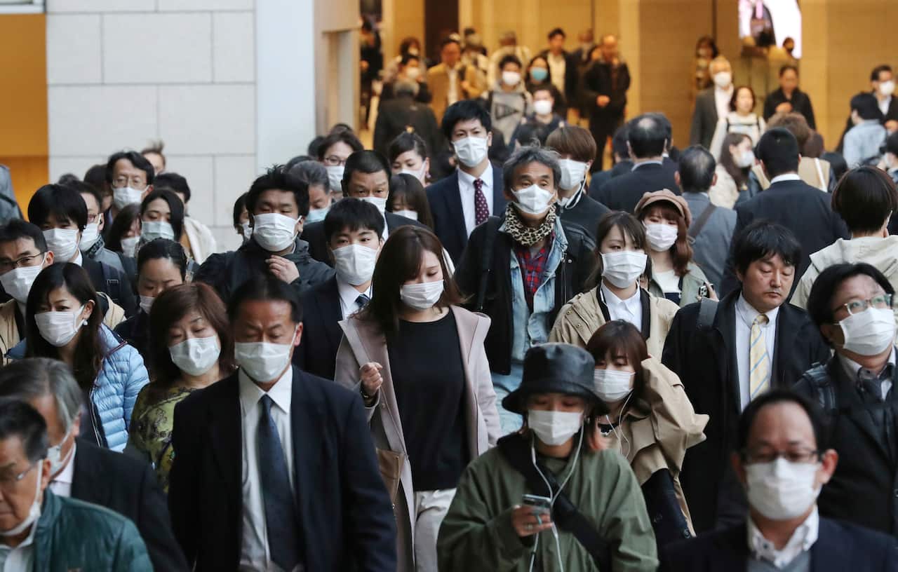People wearing masks are seen near Umeda Station in Osaka, Japan.