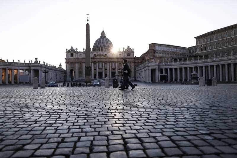 Police officers patrol an empty St. Peter's Square at the Vatican, Friday, April 10, 2020. 