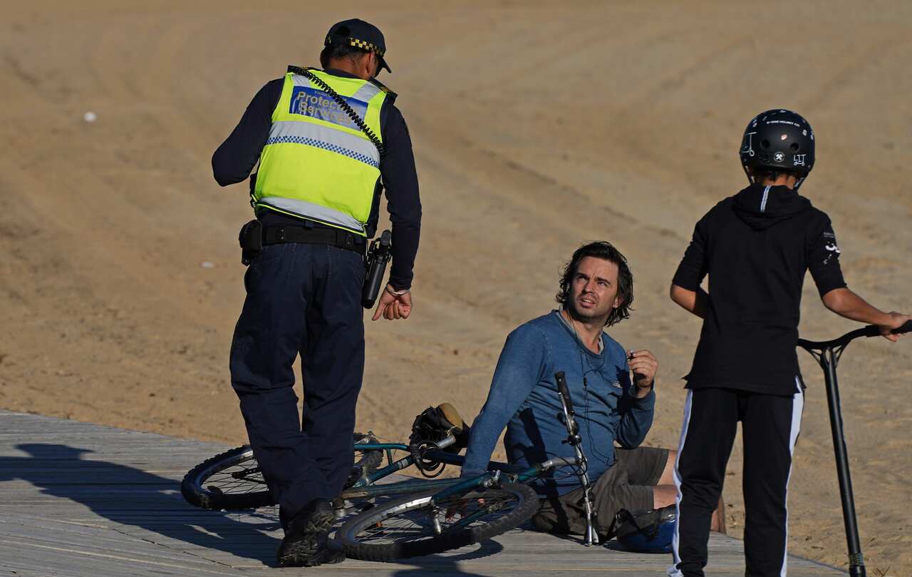 Victoria Police speak to a man at St Kilda beach in Melbourne.
