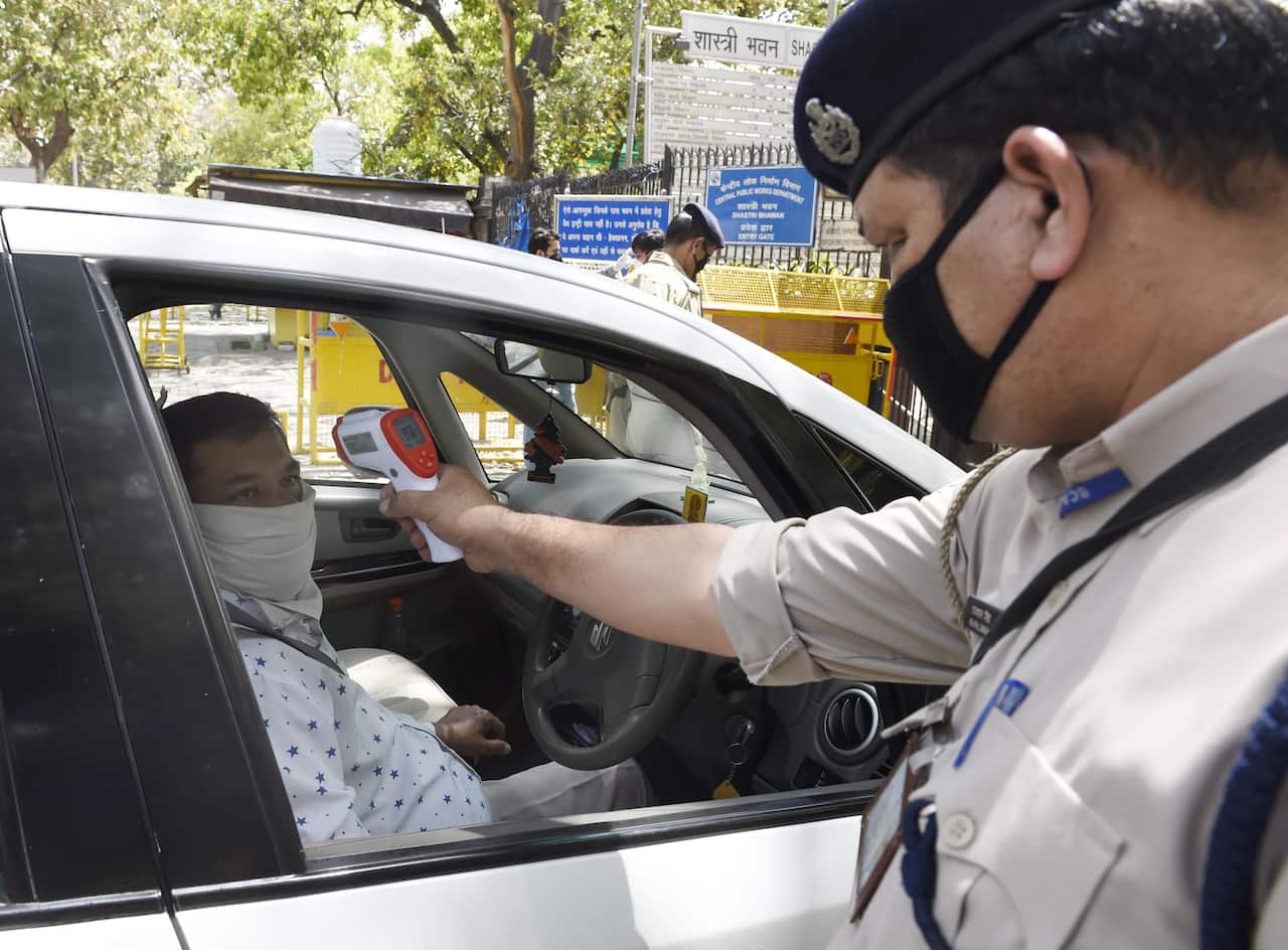 Security personnel screen government employees returning to work at the office for coronavirus symptoms. 