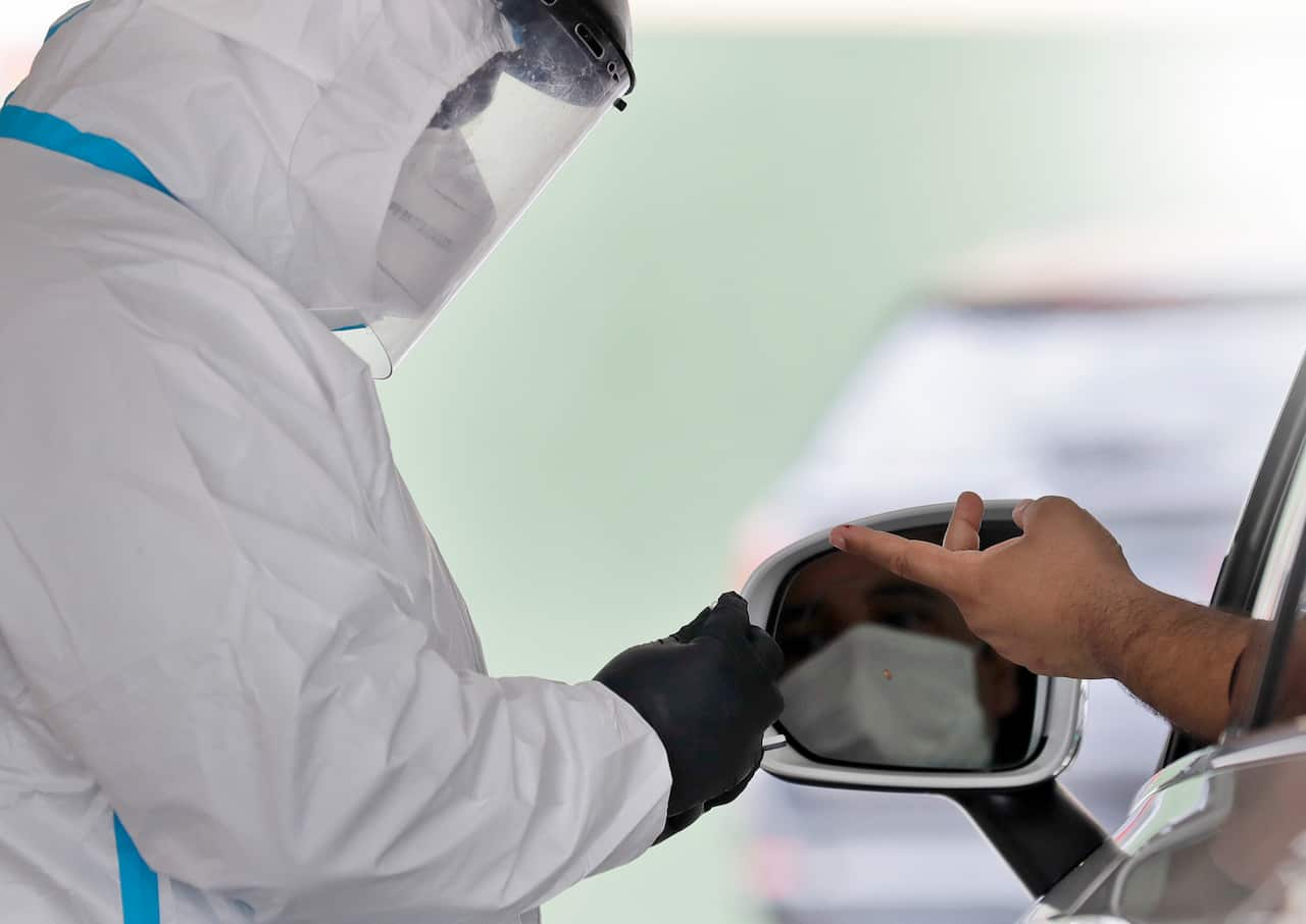 A man's blood is collected for testing of coronavirus antibodies at a drive through testing site in New York.