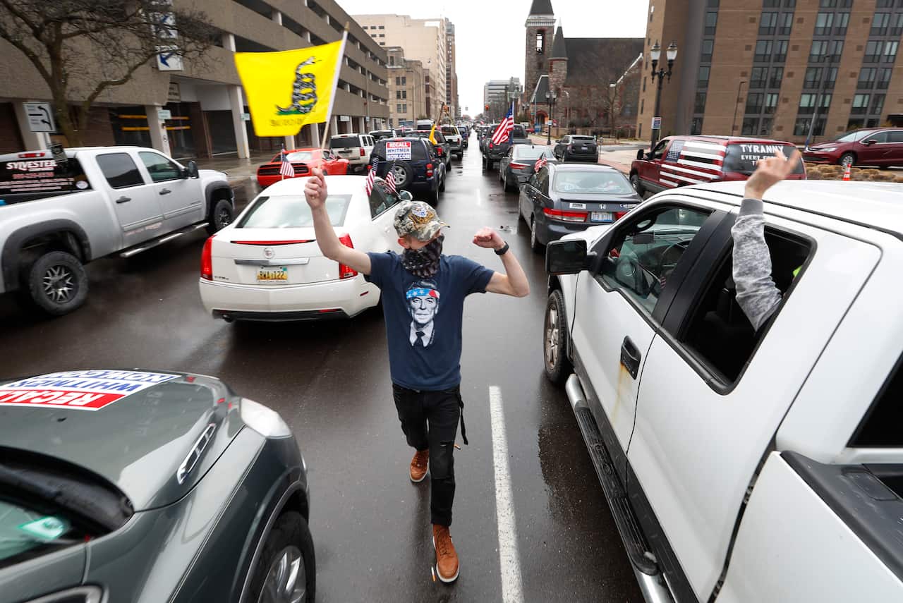 Flag-waving, honking protesters drove past the Michigan Capitol on Wednesday to show their displeasure with the lockdown during the COVID-19 outbreak. 