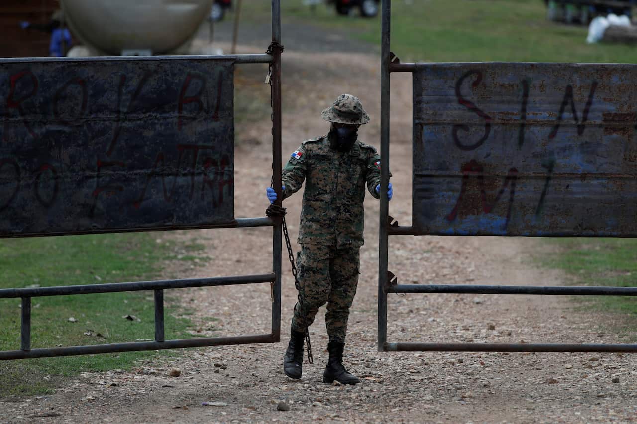 An agent from the National Border Service of Panama closes the access door to a shelter for migrants.