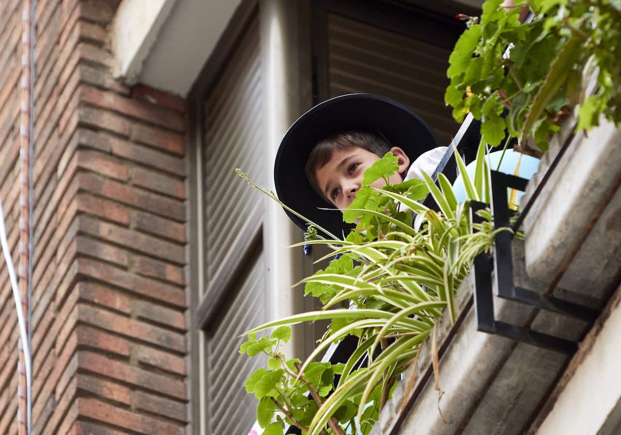 A child looks out from his balcony during Spain's strict lockdown in Toledo.