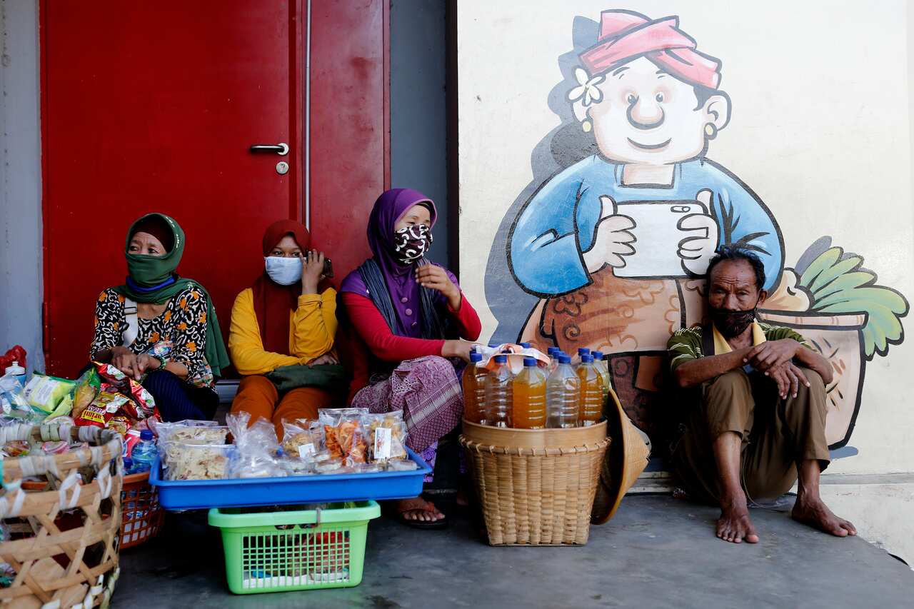 Street vendors wear face masks amid fears of the new coronavirus outbreak, at a market in Bali, Indonesia.