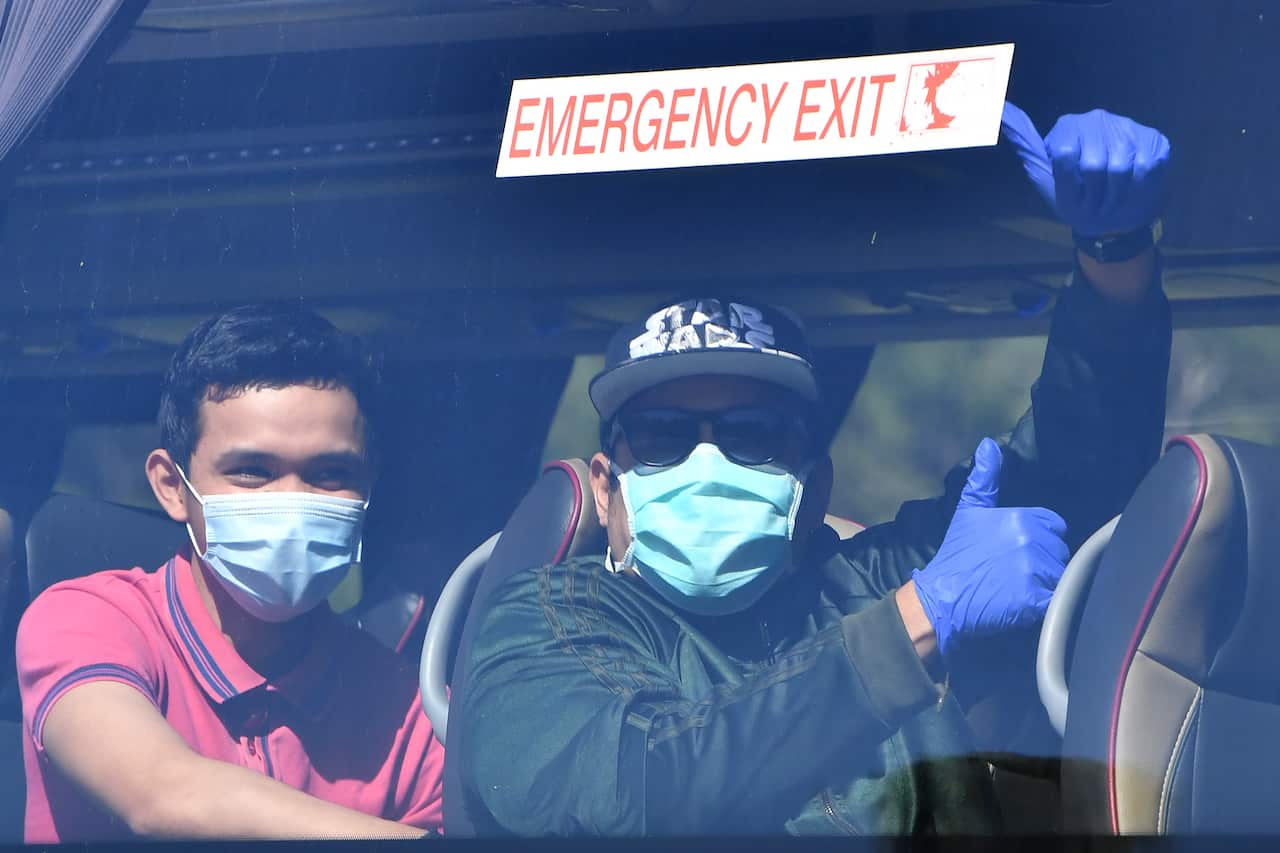 Crew from onboard the Ruby Princess cruise ship are seen departing Port Kembla in buses in Wollongong.