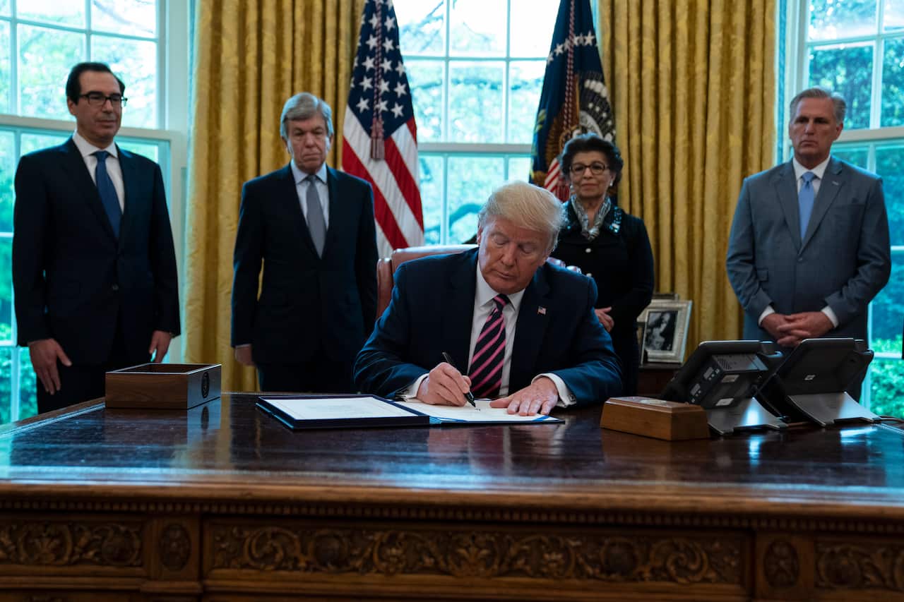 US Donald Trump signs a coronavirus aid package in the Oval Office of the White House, April 24, 2020
