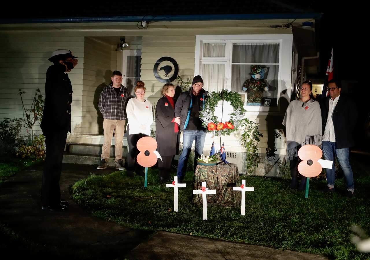 Neighbours gather at dawn to commemorate Anzac Day in a suburb of Christchurch, New Zealand.