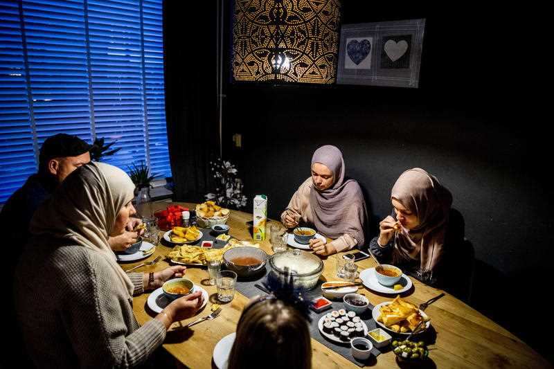 A family eat at the table during the iftar, the meal after sunset during the Islamic fasting month of Ramadan, in Rotterdam, The Netherlands