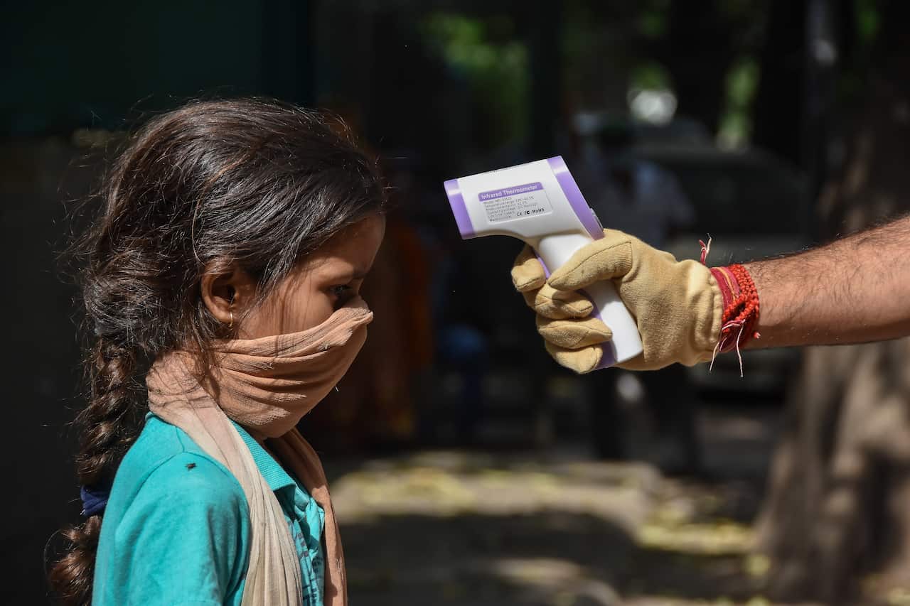 A child has her temperature taken in a Delhi slum.