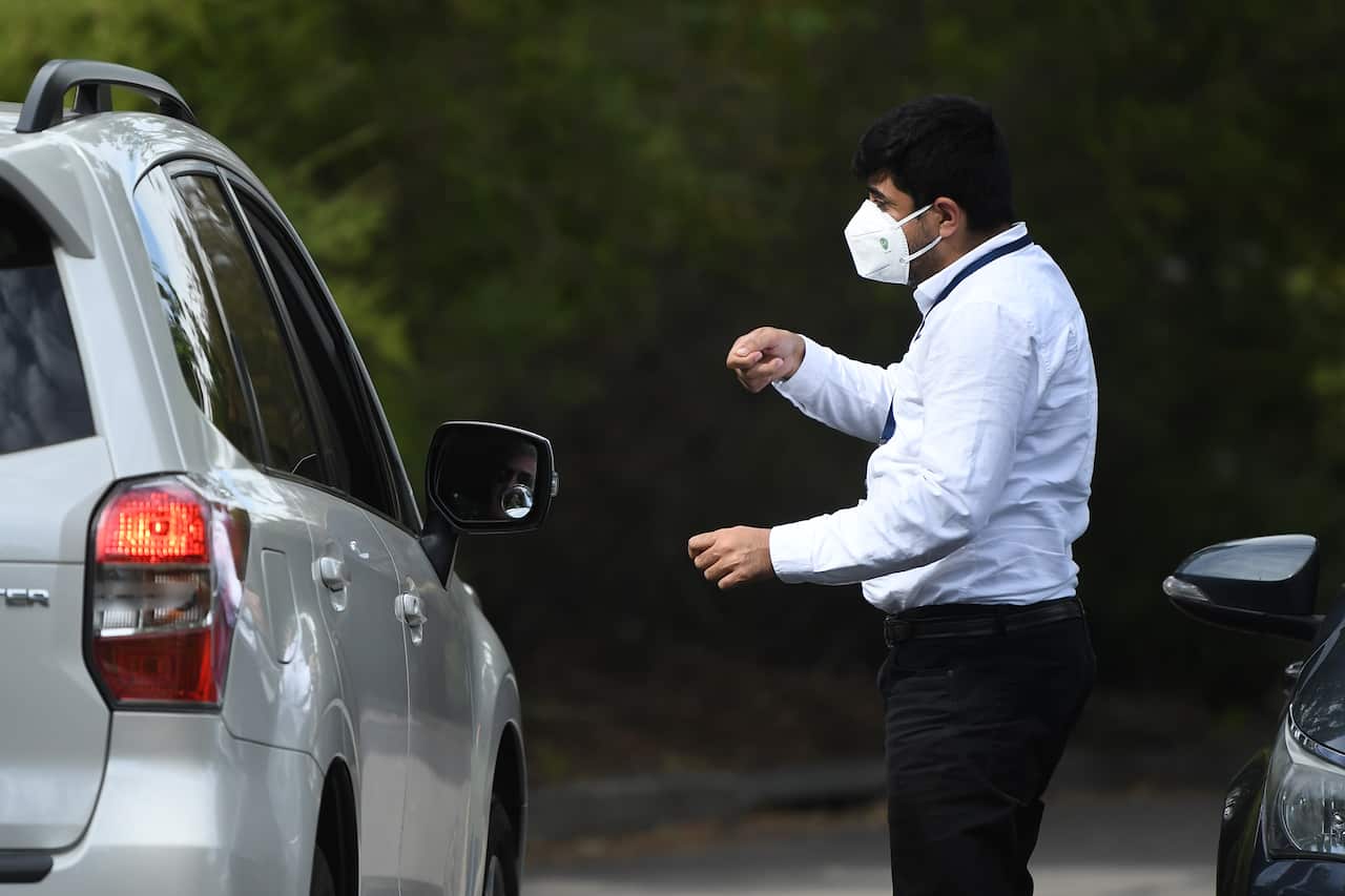 A security guard speaks with people arriving at the Anglicare Newmarch House in western Sydney.