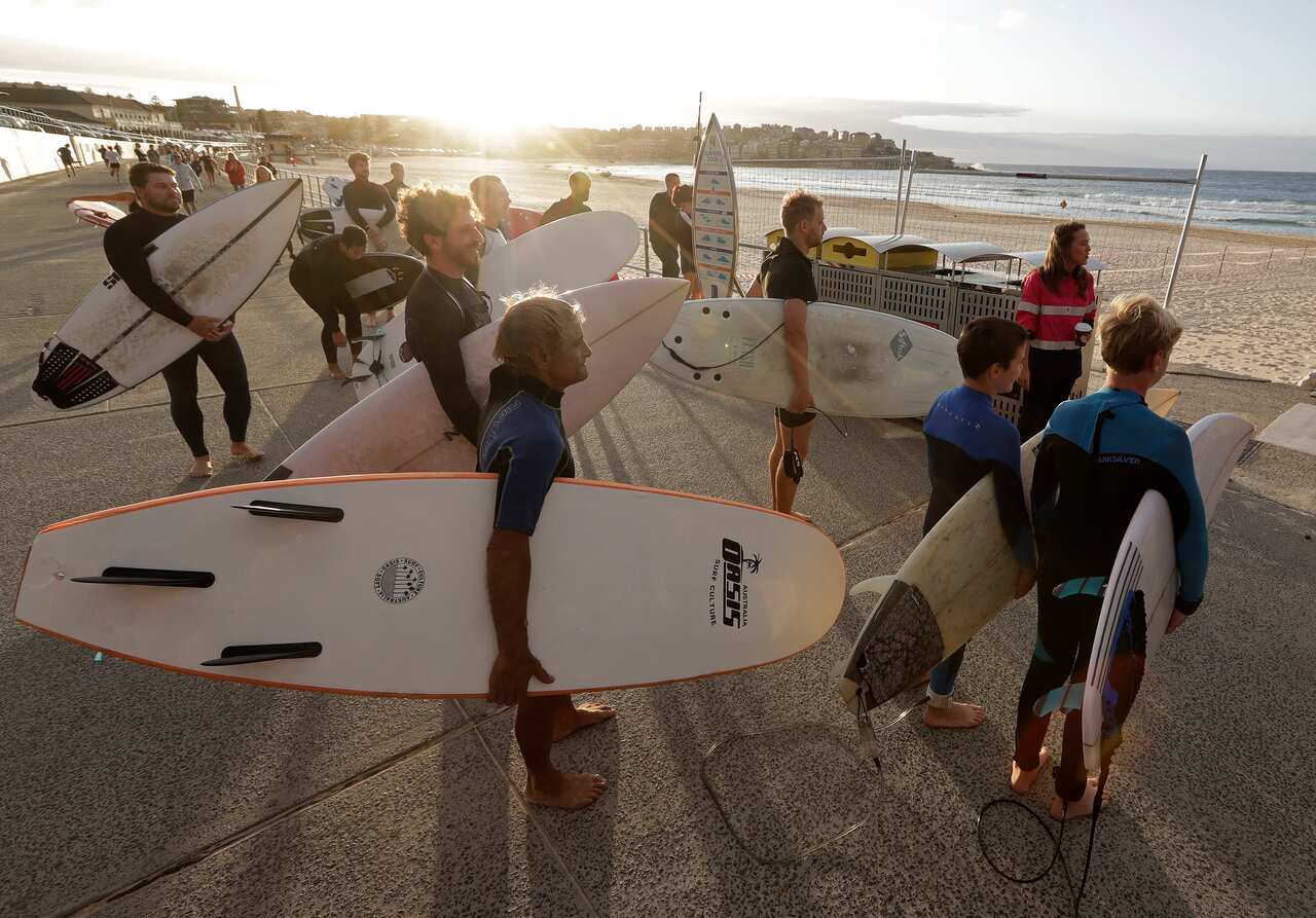Surfers wait for officials to open Bondi Beach on Tuesday as the beach was partially reopened.