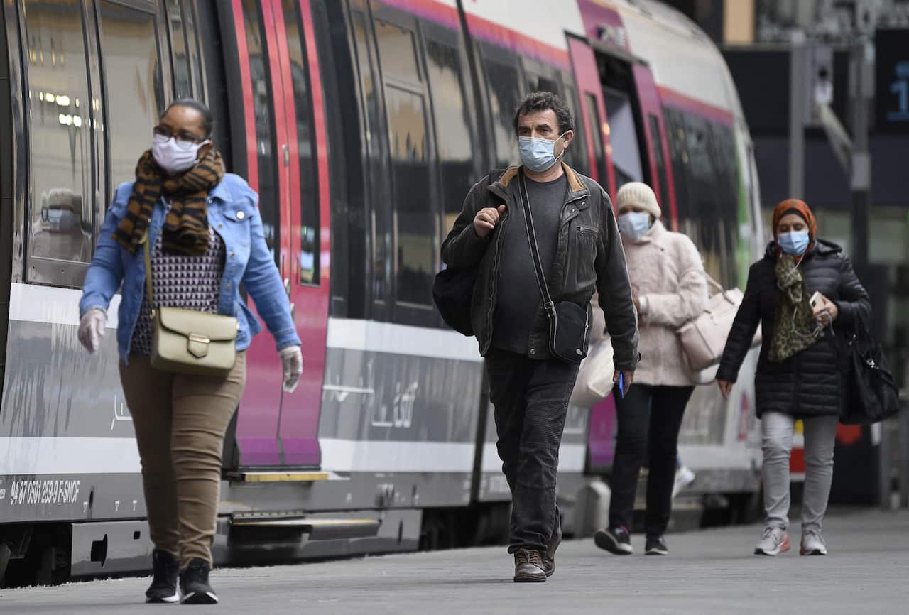 People wearing a protective mask and alternative mask arrive at the train station Gare Saint Lazare in Paris, France,  28 April  2020.