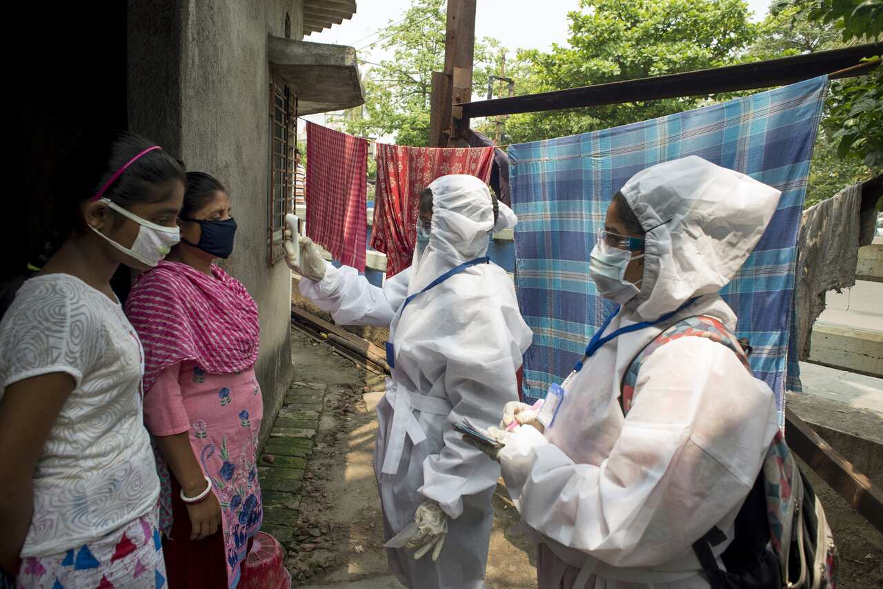 Healthcare workers take temperatures in a Kolkata slum.