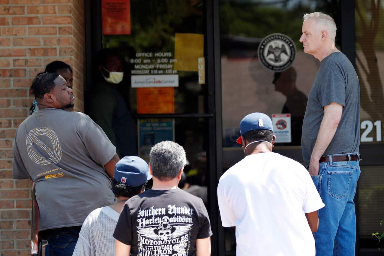 People who lost their jobs wait in line to file for unemployment in Pearl, Mississippi.