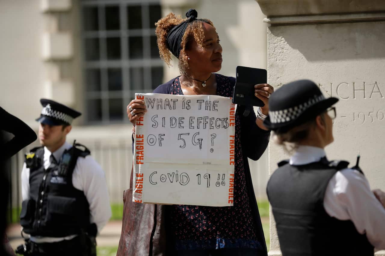 A woman holds up a placard at a coronavirus anti-lockdown, anti-vaccine, anti-5G and pro-freedom protest in London.