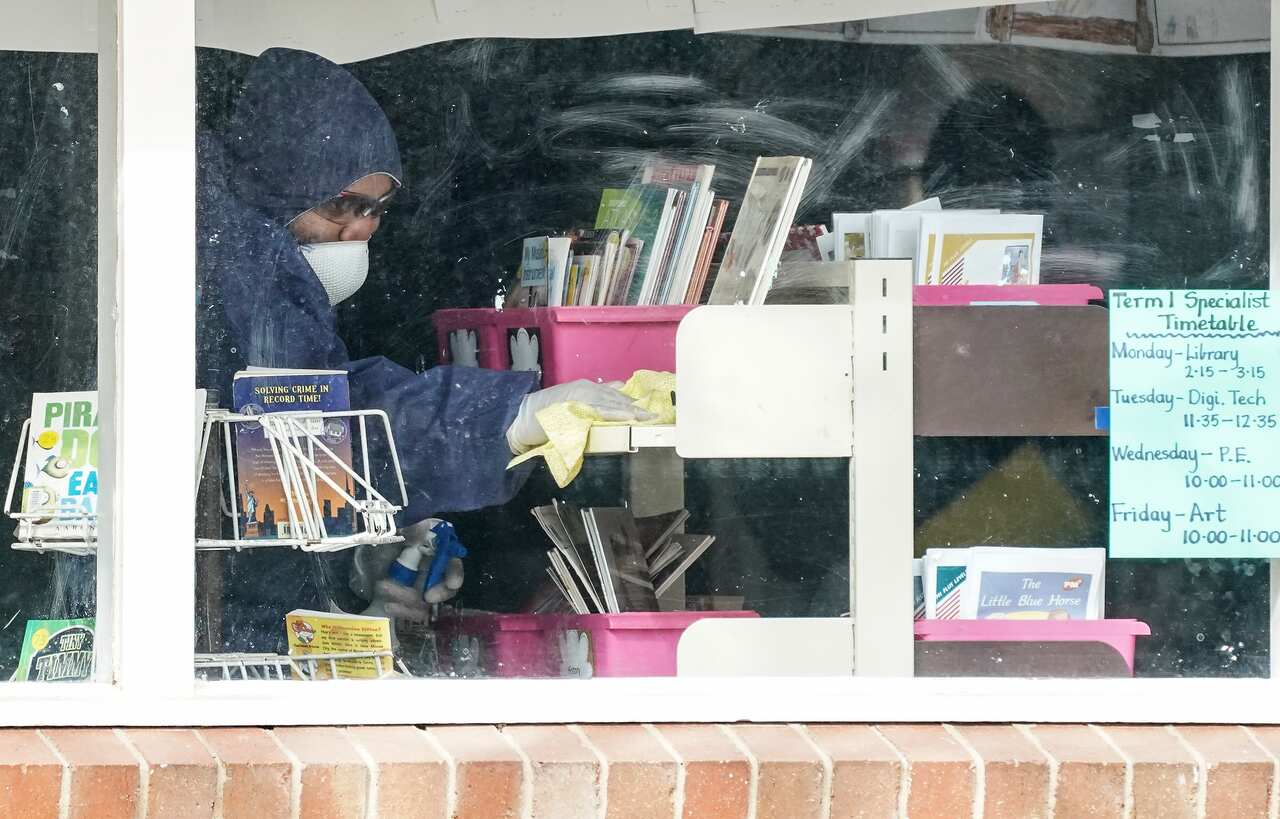 A cleaner is seen inside of a classroom at Meadowglen Primary School in Melbourne. 