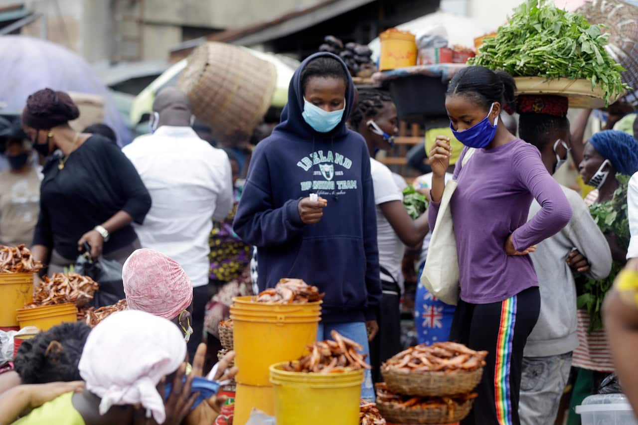 Shoppers at a Nigerian fish market wear face masks to prevent the spread of COVID-19.
