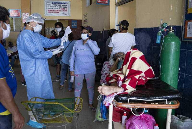 A doctor in a biosafety suit reviews a medical history in a room with COVID-19 patients at the Regional Hospital of Iquitos, in Iquitos, Peru, 07 May 2020
