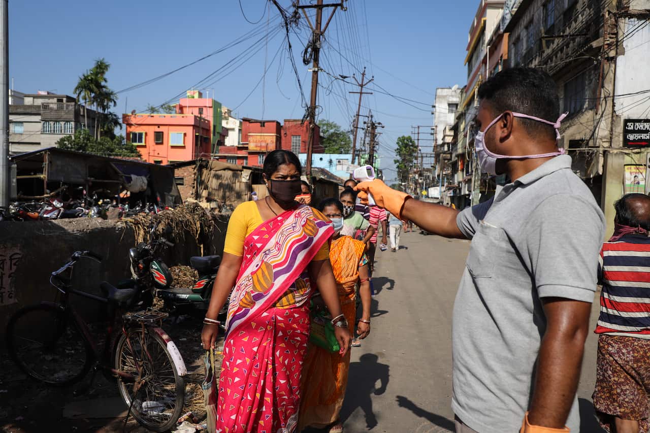 Health officials thermal screening every person at a local market after the Indian government imposed a nationwide lockdown. 