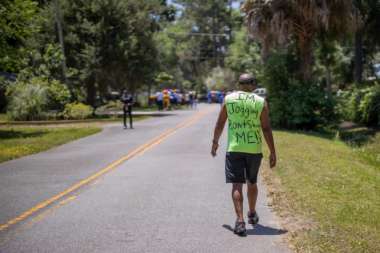 People gather at the small memorial at the site of the shooting death of unarmed black jogger Ahmaud Arbery in Brunswick, Georgia.