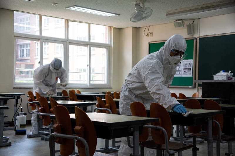 Health officials of the Songpa-gu in Seoul spray disinfectant in a classroom of the Yeongdongil High School in Seoul, South Korea, 11 May 2020