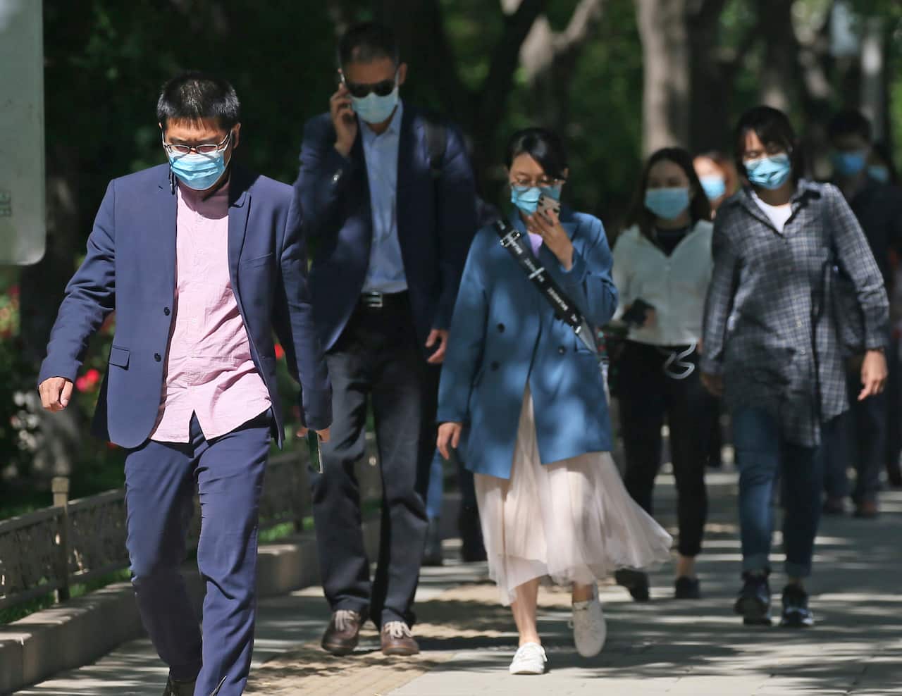 People wearing face mask are seen during commuting time at a street in Beijing, China.