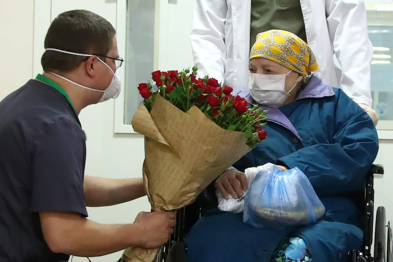 Doctors congratulate Pelageya Poyarkova on her 100th birthday as she is discharged from an infectious diseases facility in Russia.