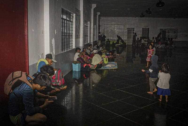 Citizens take shelter inside an evacuation center as Typhoon Vongfong makes landfall in the town of Can-avid, Eastern Samar province, the Philippines, 14 May