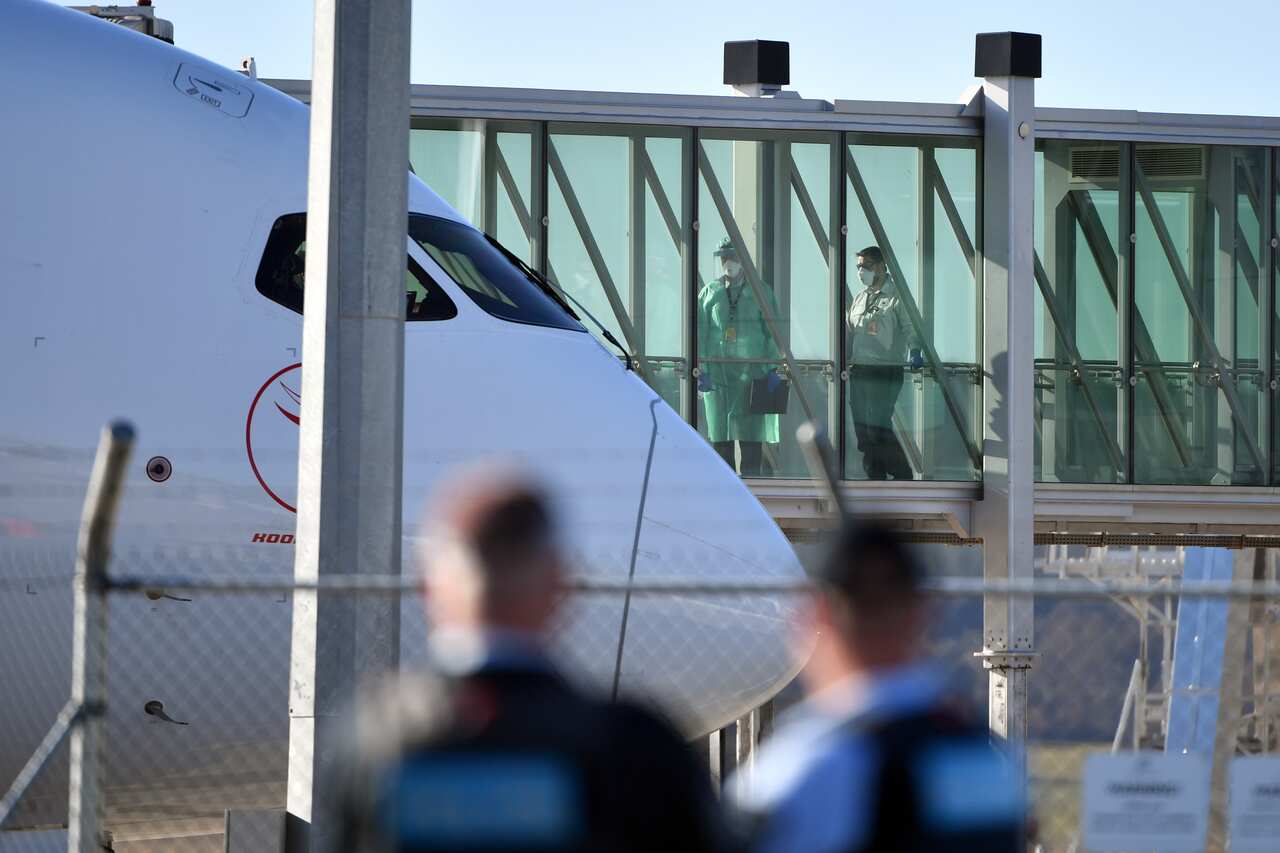 Health officials wait for Australians stranded in India to disembark a Qantas plane at Canberra Airport in May.