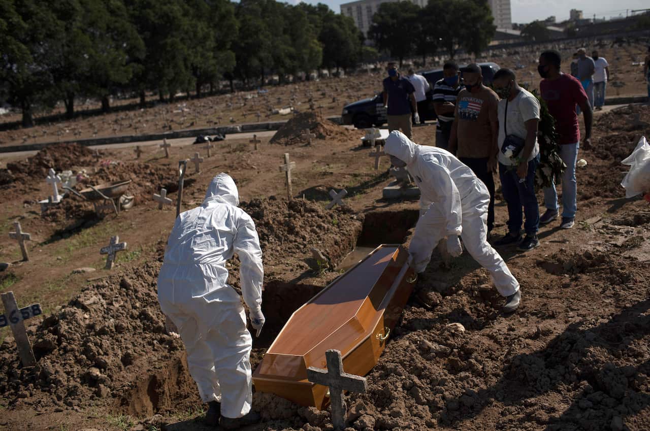Cemetery workers in protective gear bury Amanda da Silva, 22, who died of COVID-19 at the Caju cemetery, in Rio de Janeiro, Brazil.