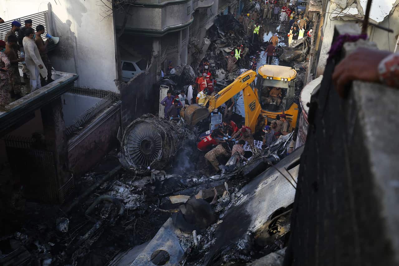 Officials try to salvage the wreckage of the passenger plan at the crash scene in a residential area, in Karachi, Pakistan.