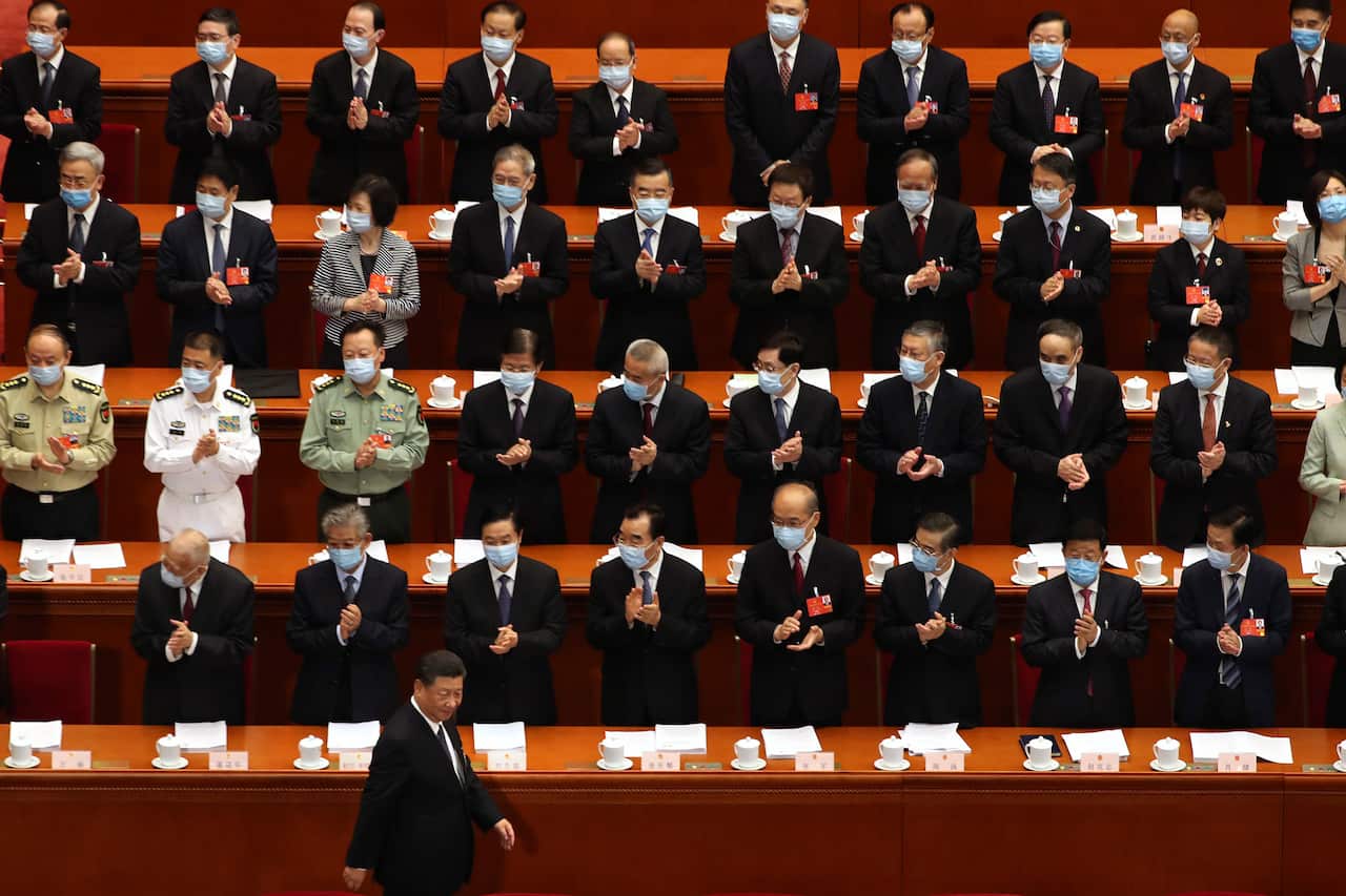 Delegates applaud as Chinese President Xi Jinping arrives for the opening session of China's National People's Congress (NPC) in Beijing.