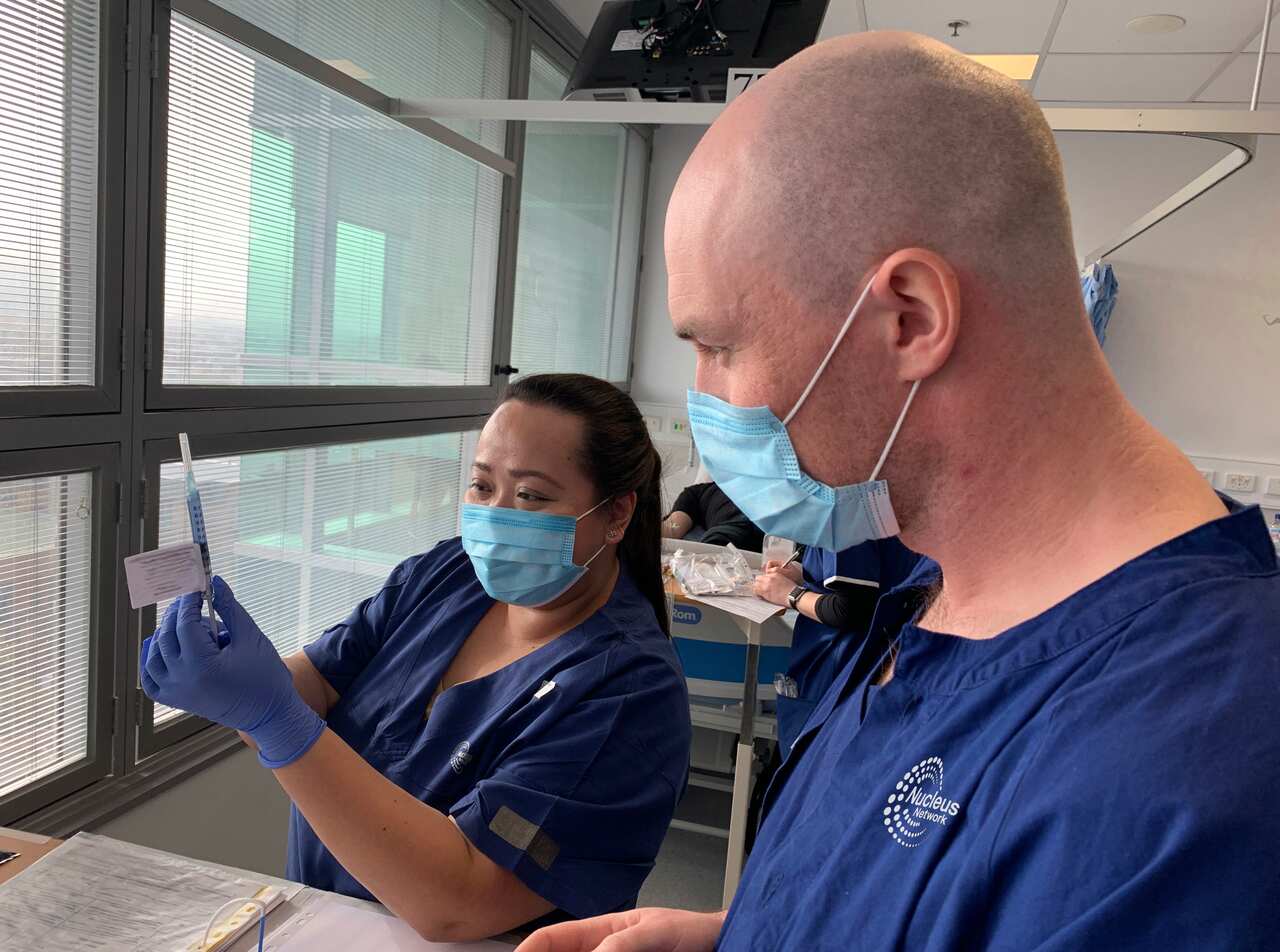 Technicians prepare for a clinical trial of a coronavirus vaccine in Melbourne.