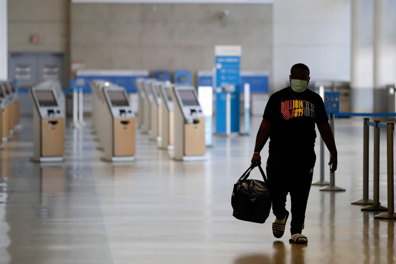 A traveller walks in a mostly empty American Airlines terminal at the Los Angeles International Airport in May. 