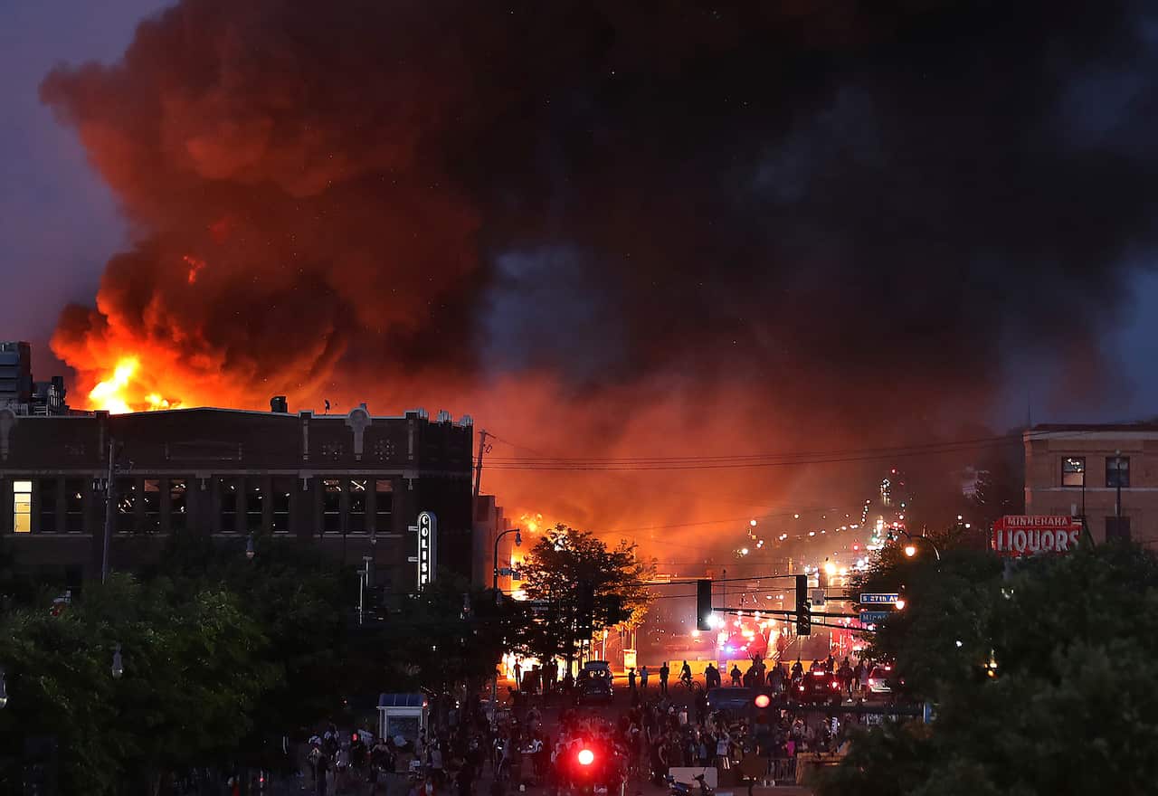 Seen from Hiawatha Avenue, a large fire burns Thursday, May 28, 2020, in Minneapolis during a third night of unrest following the death of George Floyd while in Minneapolis police custody Monday. (David Joles/Star Tribune via AP)