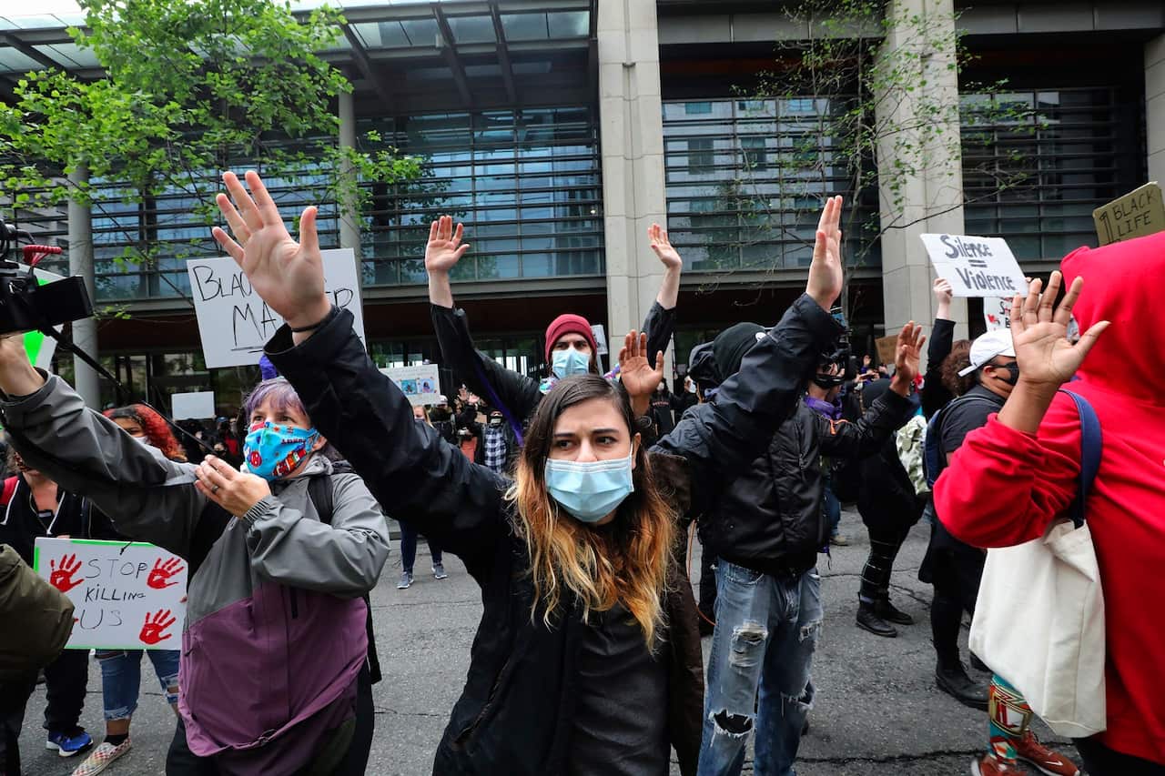 Protesters in Seattle raise their arms to the chants of "hands up, don't shoot".