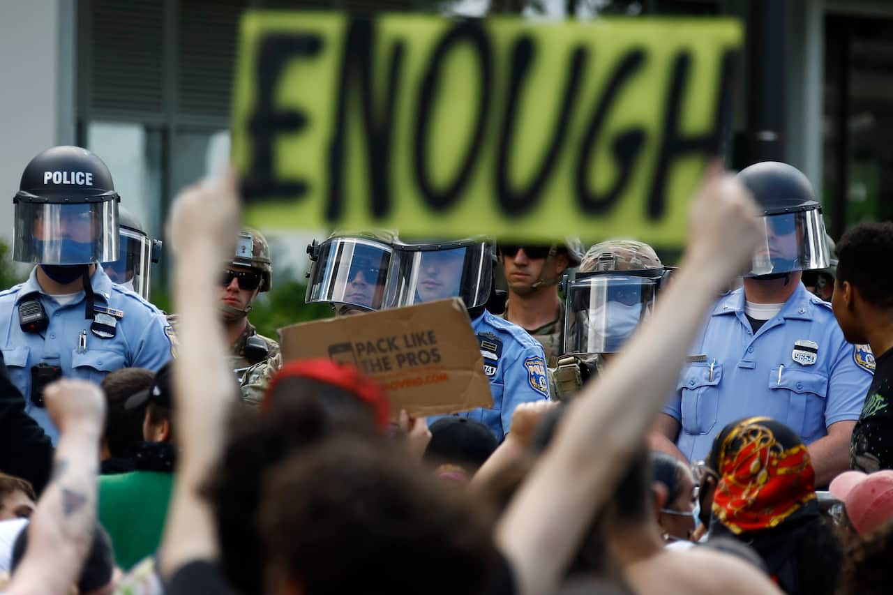 Protesters rally as Philadelphia Police officers and Pennsylvania National Guard soldiers look on, Monday, 1 June, 2020